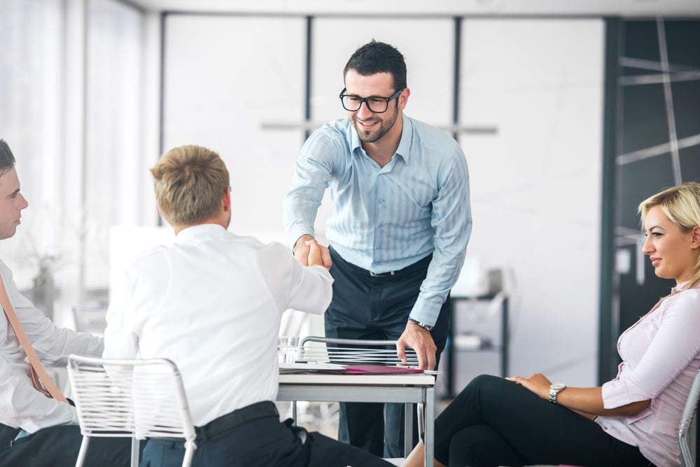 Business people shaking hands on a company meeting after resolving a boardroom dispute