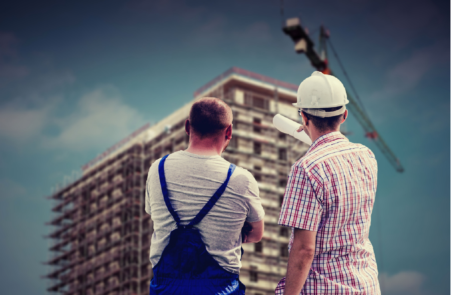 Two male surveyors looking at building