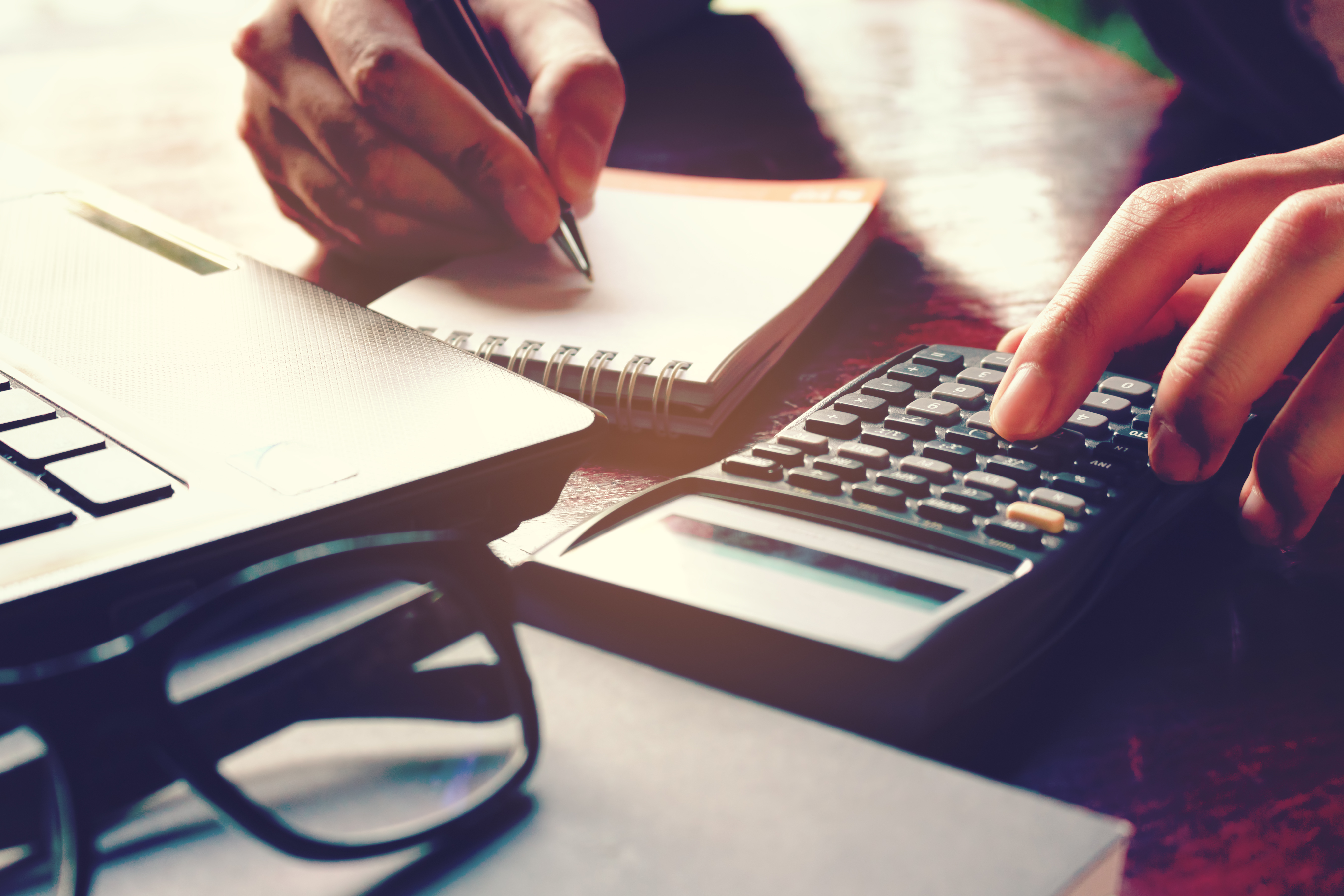 A businessman calculating taxes at his desk, representing business insolvency help from McAlister & Co